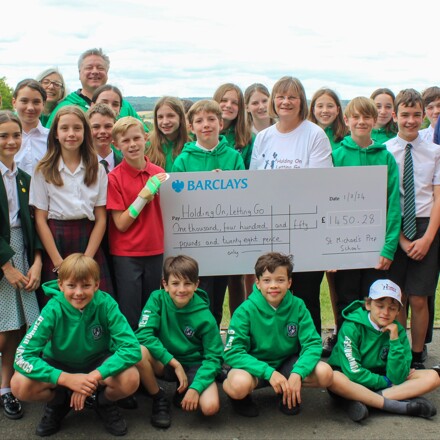 School play cast present cheque to bereavement charit